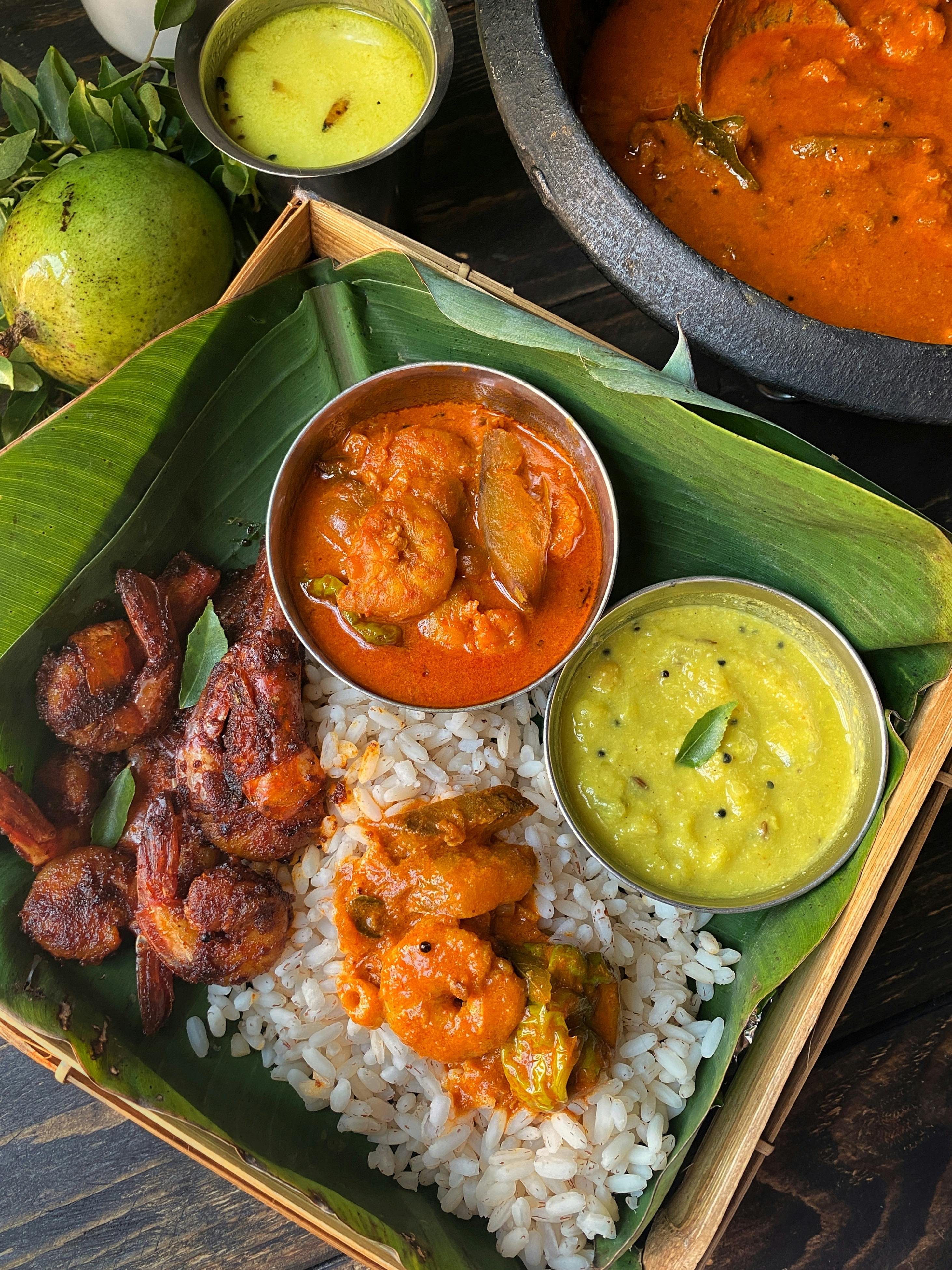 A spread of coastal Indian seafood dishes including Goan fish curry, Bengali fish preparations, and Kerala-style prawns